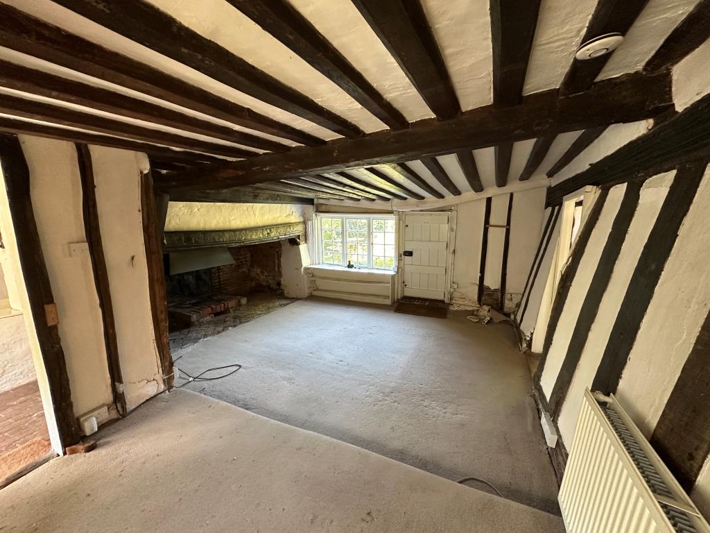 Lot: 115 - DETACHED THATCHED COTTAGE IN NEED OF REPAIR ON 1.36 ACRES OF LAND - Living room with inglenook fireplace